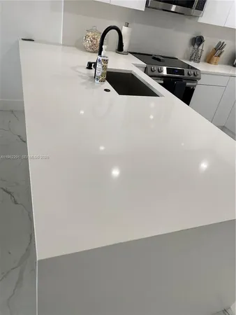 a close view of a sink a faucet and appliances in the kitchen