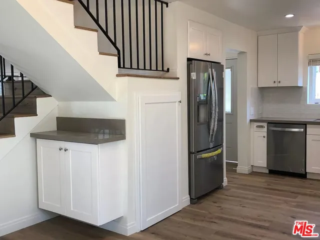 a kitchen with stainless steel appliances granite countertop a refrigerator and a stove top oven
