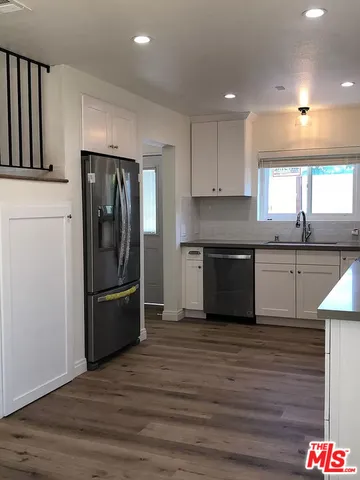 a kitchen with stainless steel appliances granite countertop a refrigerator and a sink