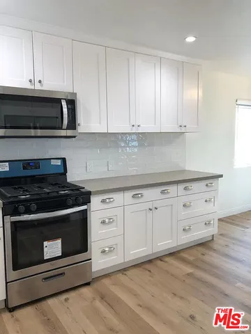 a kitchen with stainless steel appliances granite countertop a stove a microwave and cabinets