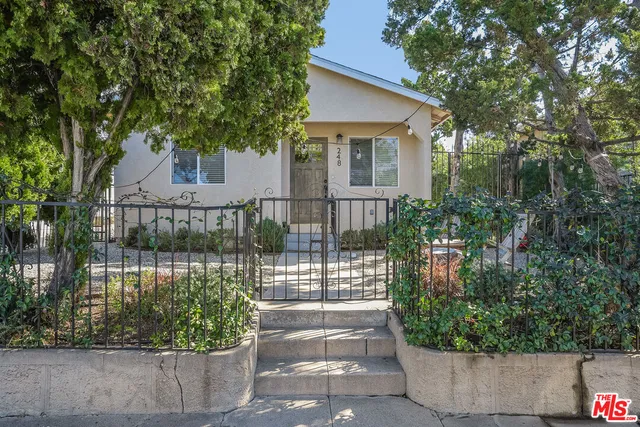 a front view of a house with a garden