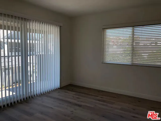 an empty room with wooden floor and a window