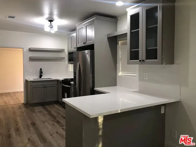 a kitchen with stainless steel appliances a refrigerator and a stove top oven