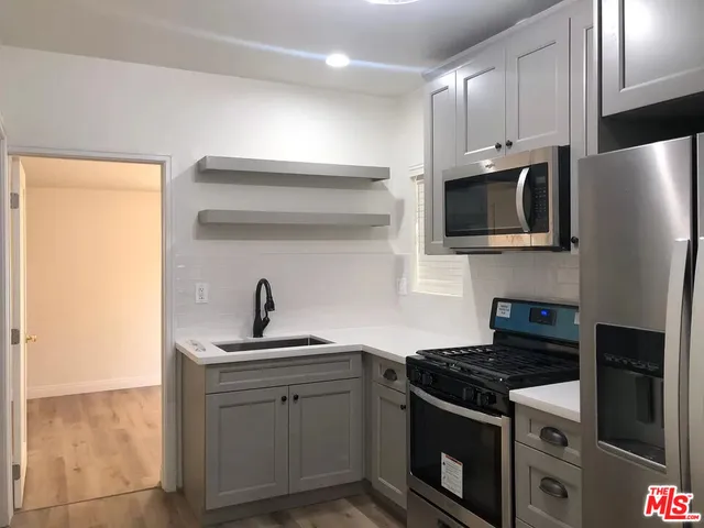 a kitchen with granite countertop a sink stove and refrigerator