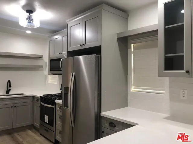 a kitchen with stainless steel appliances granite countertop a refrigerator and a sink