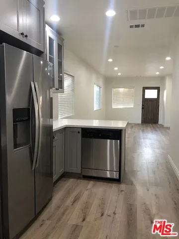 a kitchen with stainless steel appliances granite countertop a refrigerator a sink and a stove