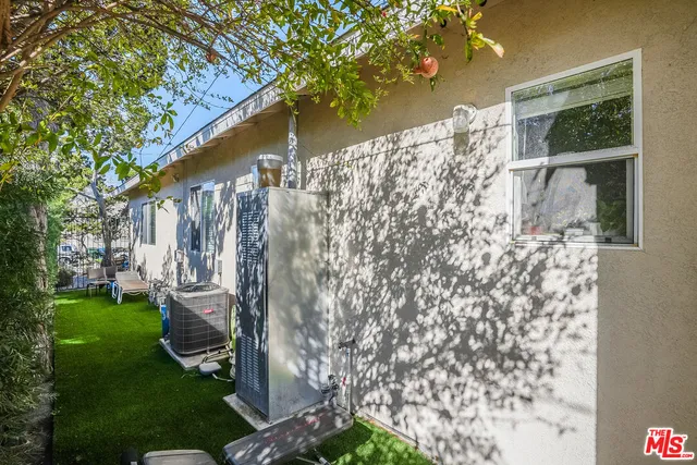 a backyard of a house with large trees and plants