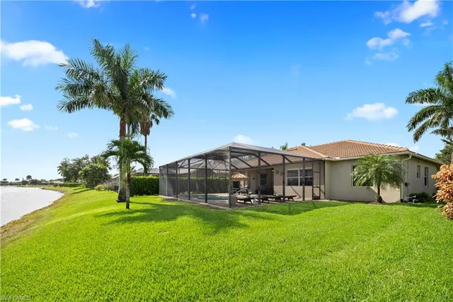 a view of a big house with a big yard and palm trees