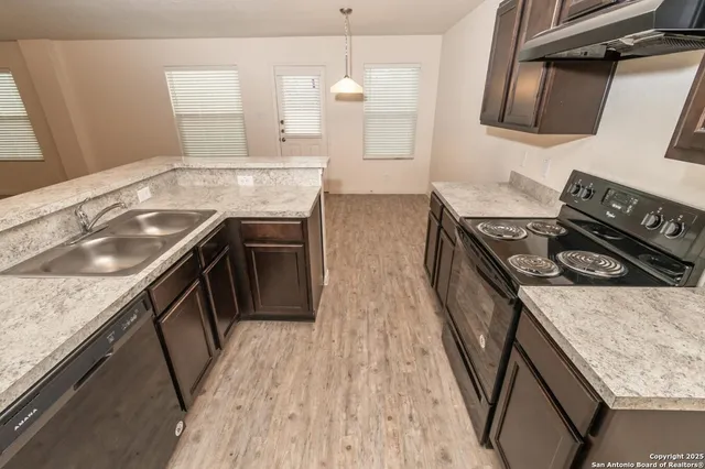 a kitchen with granite countertop a stove and a sink