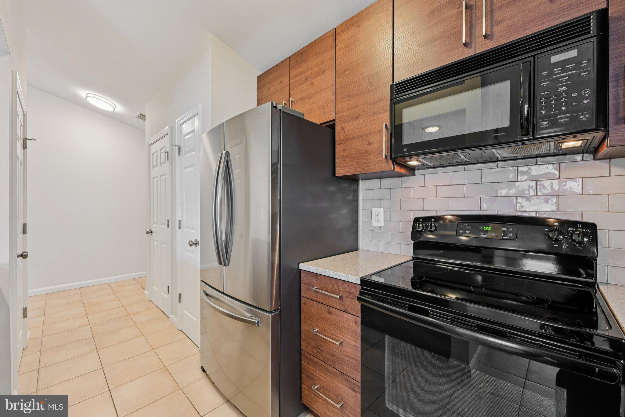 2104 Whitehall Road, Unit 2B Frederick, MD 21702 - Photo 14 of 37 a kitchen with granite countertop a refrigerator stove and microwave