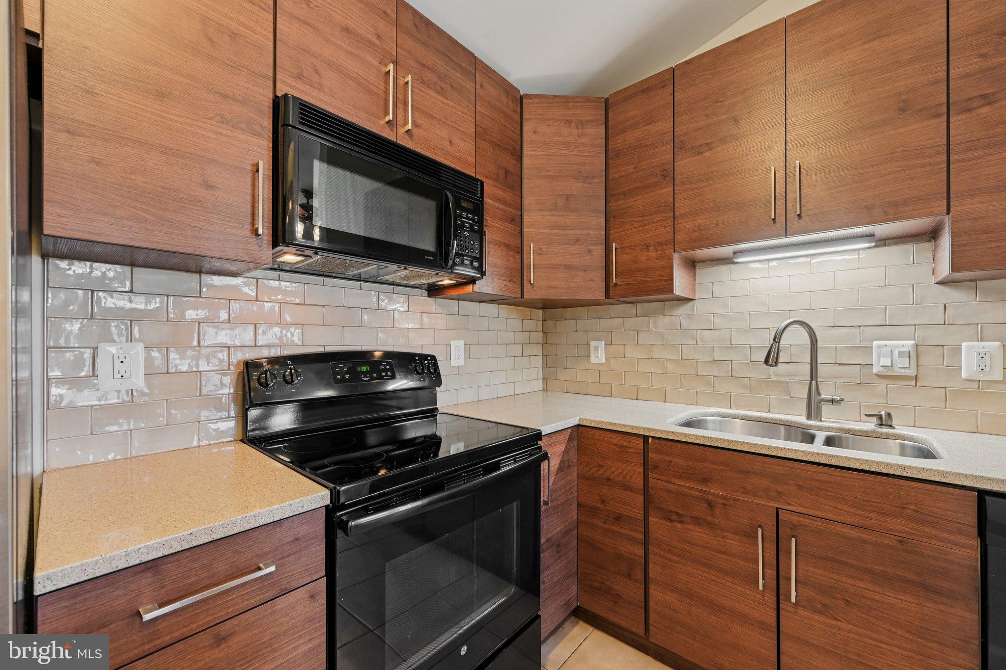 2104 Whitehall Road, Unit 2B Frederick, MD 21702 - Photo 15 of 37 a kitchen with stainless steel appliances a stove a microwave a sink and cabinets