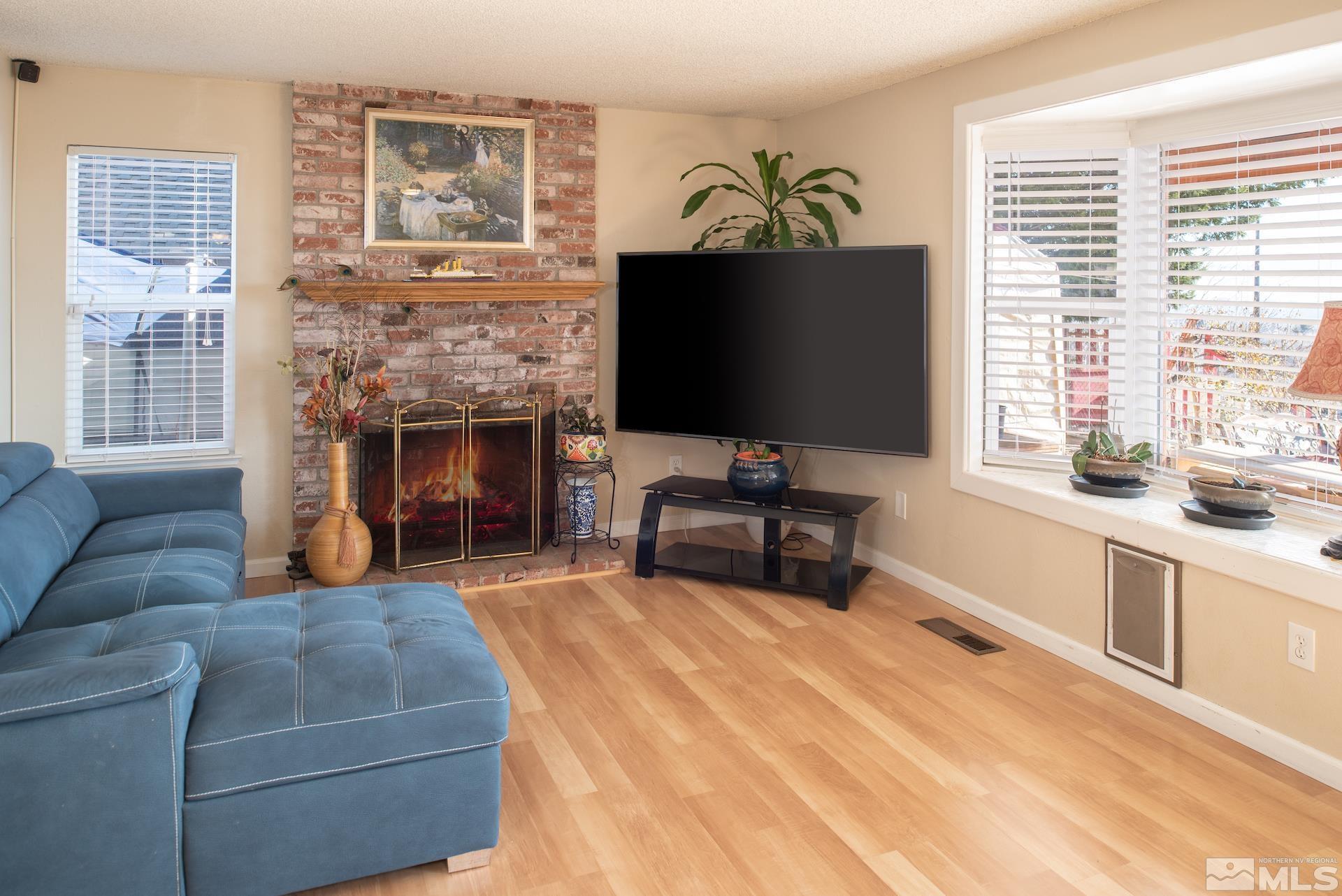 3836 Bexley Square Reno, NV 89503 - Photo 8 of 38 a living room with furniture a fireplace and a flat screen tv