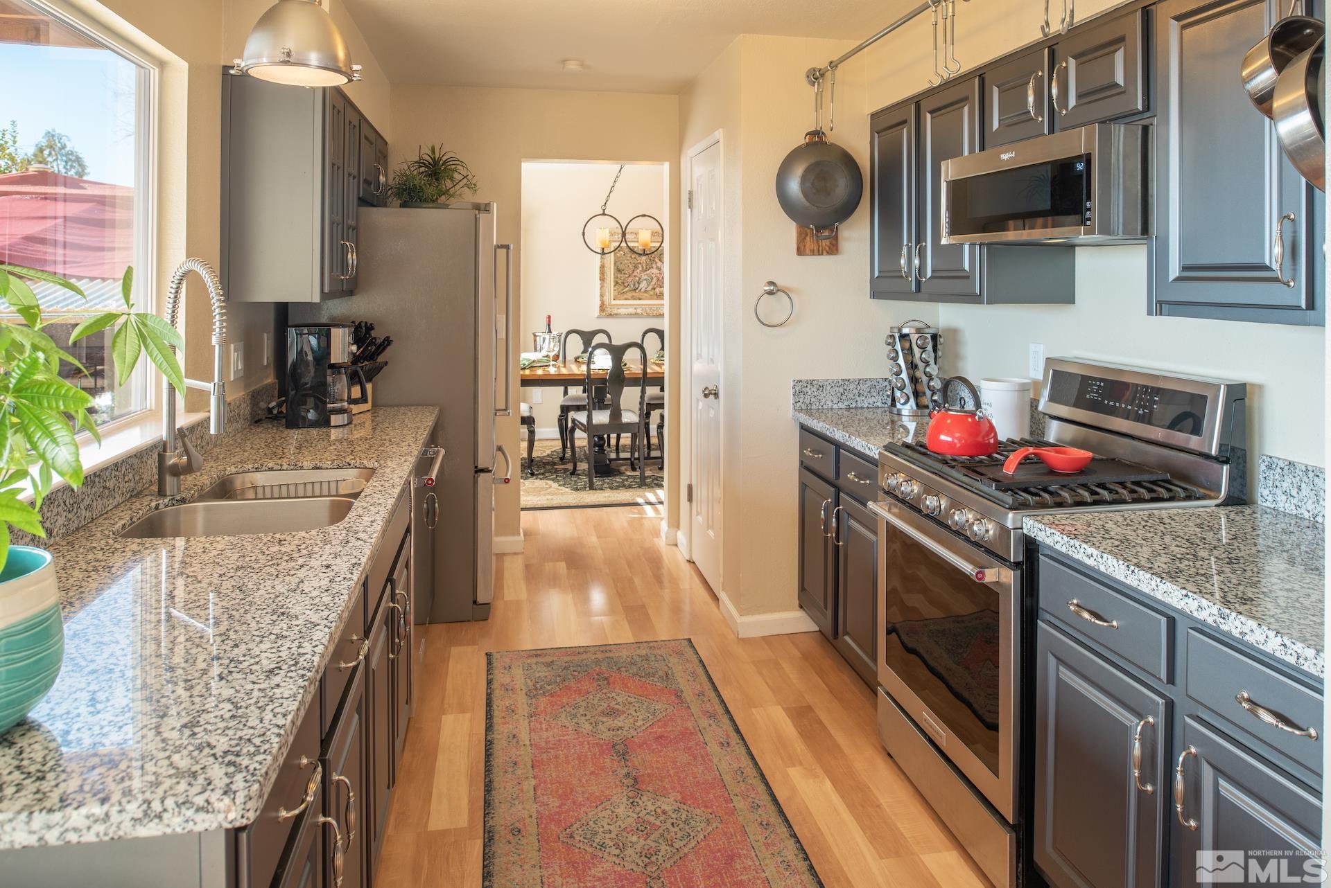 3836 Bexley Square Reno, NV 89503 - Photo 10 of 38 a kitchen with stainless steel appliances granite countertop a sink stove and refrigerator