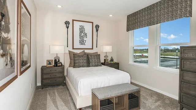 a bedroom with a bed a lamp and a large window