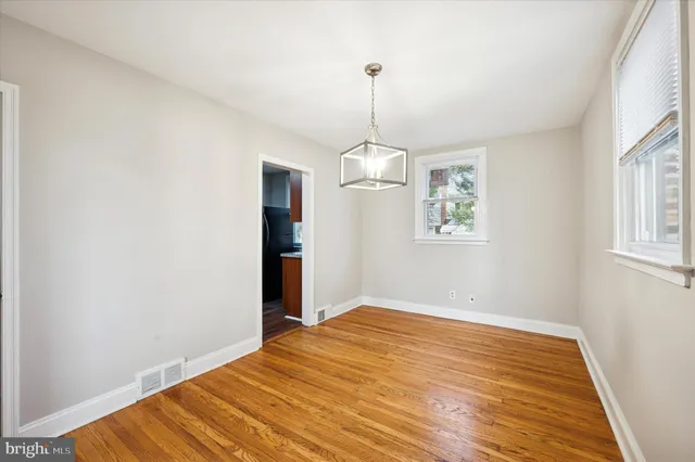 a view of empty room with wooden floor and window