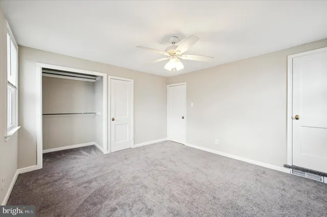 a view of an empty room with a ceiling fan