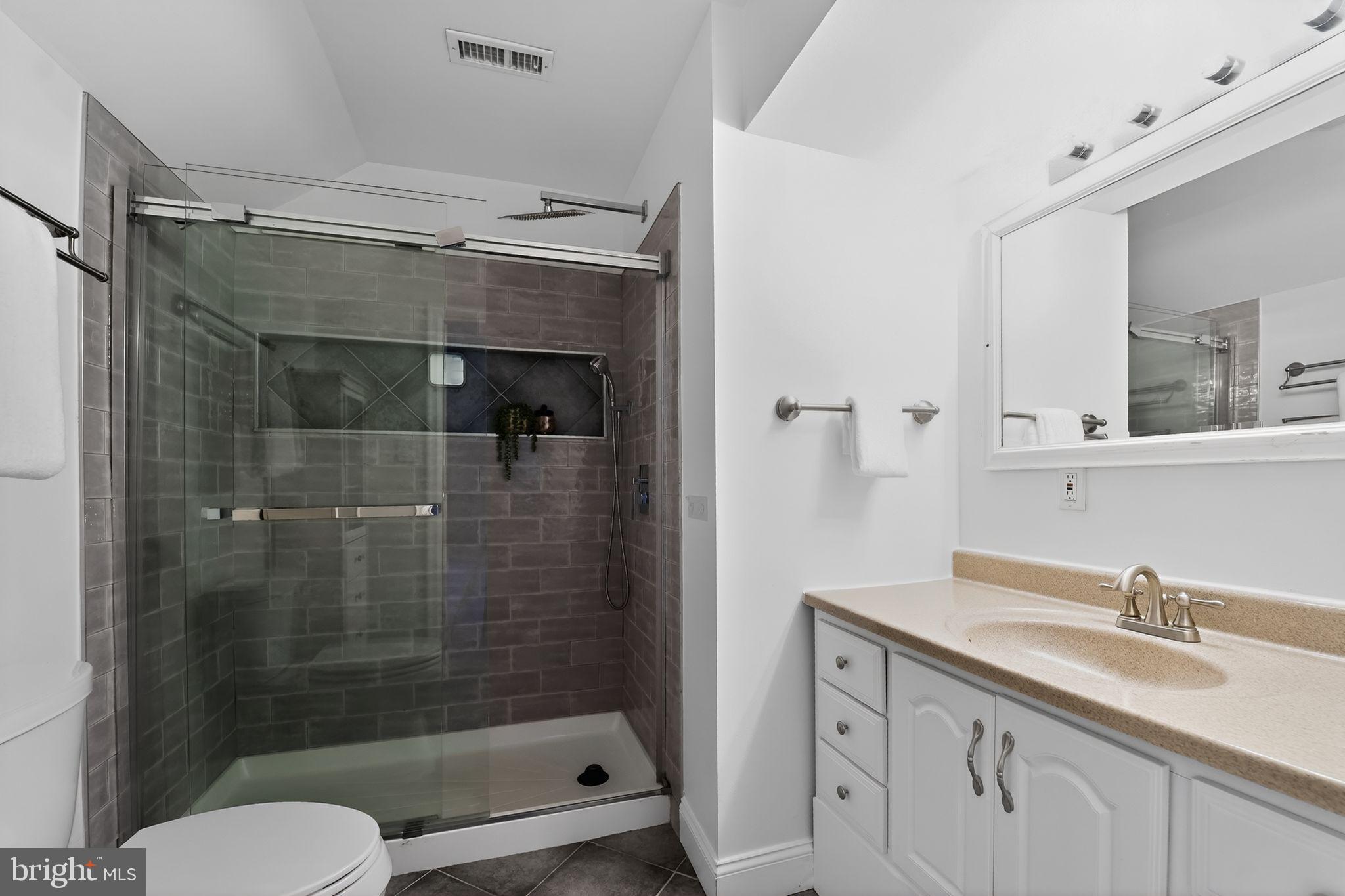 23711 Slidell Road Clarksburg, MD 20871 - Photo 21 of 31 a bathroom with a shower sink vanity mirror and toilet