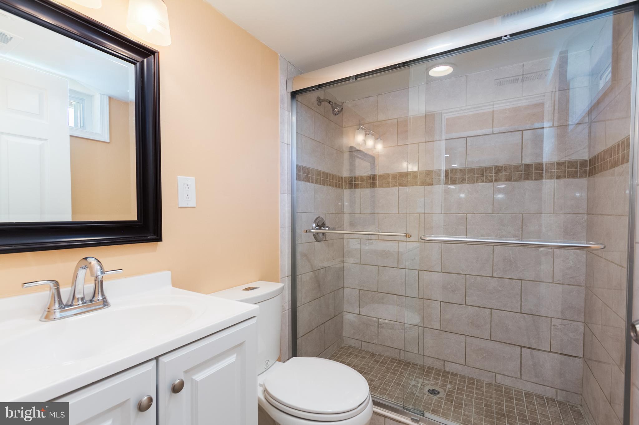 8015 Oakleigh Road Baltimore, MD 21234 - Photo 22 of 30 a bathroom with a sink toilet a mirror and shower