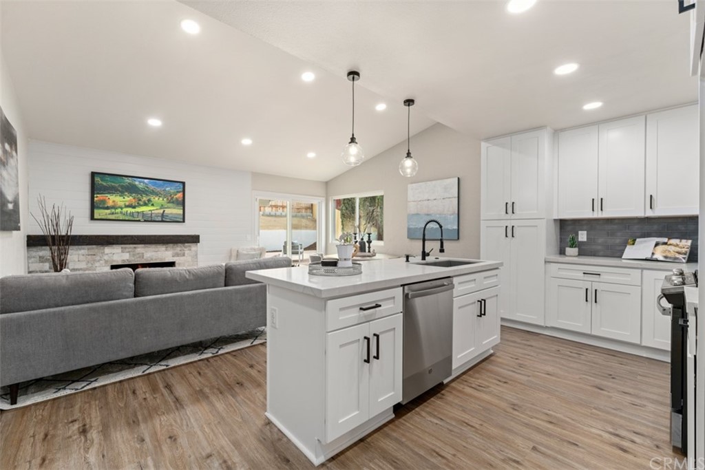 a large white kitchen with cabinets a sink and appliances