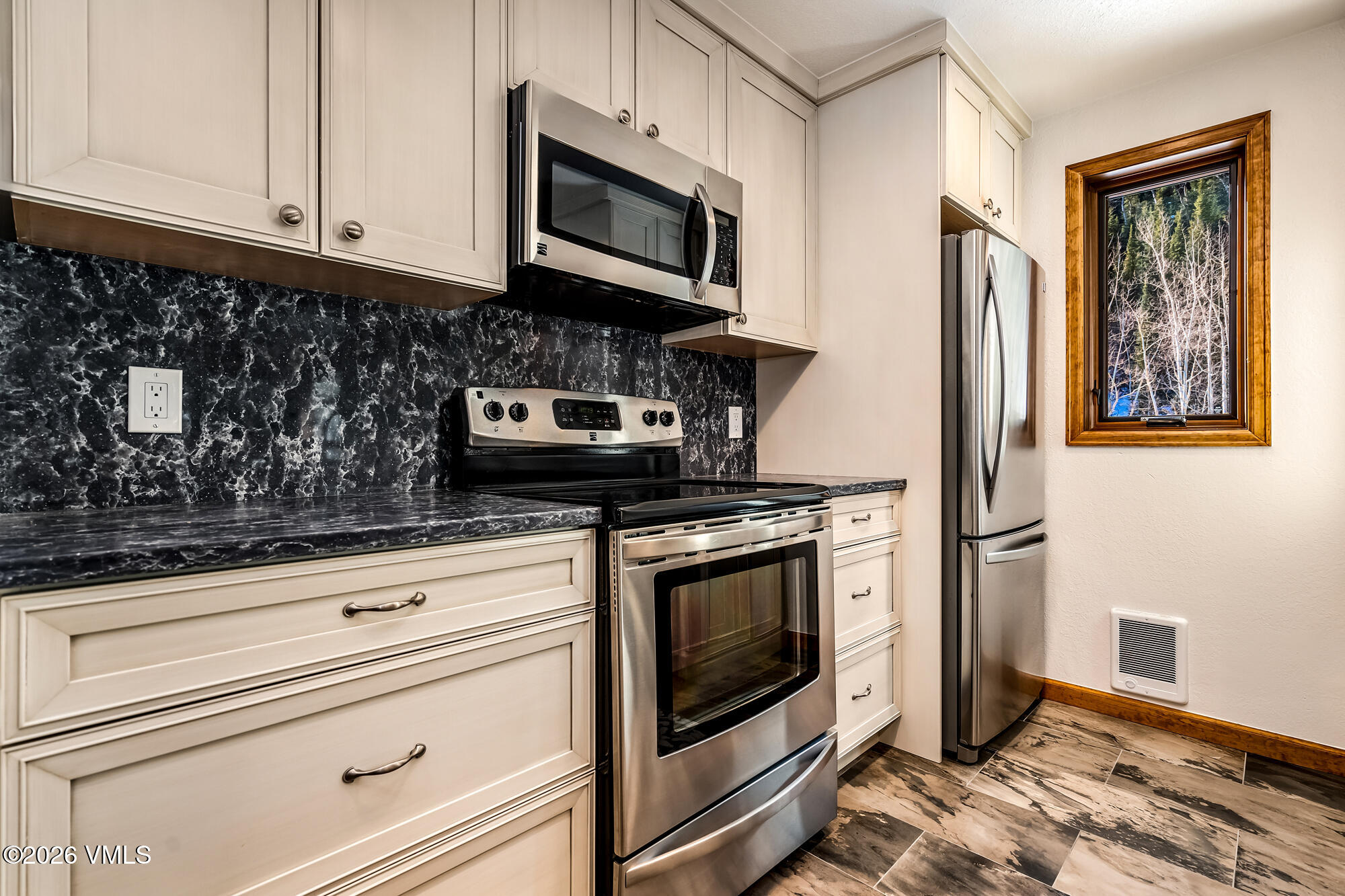 4470 Timber Falls Court, Unit 1405 Vail, CO 81657 - Photo 11 of 35 a kitchen with stainless steel appliances granite countertop a stove microwave and cabinets