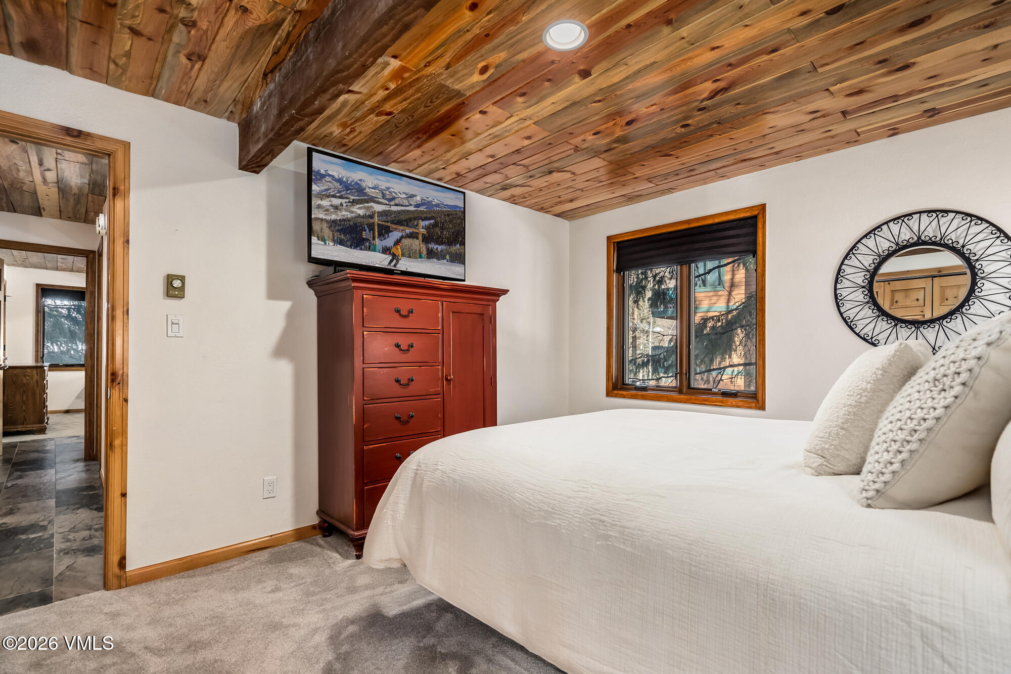 4470 Timber Falls Court, Unit 1405 Vail, CO 81657 - Photo 17 of 35 a bedroom with a bed and a chandelier