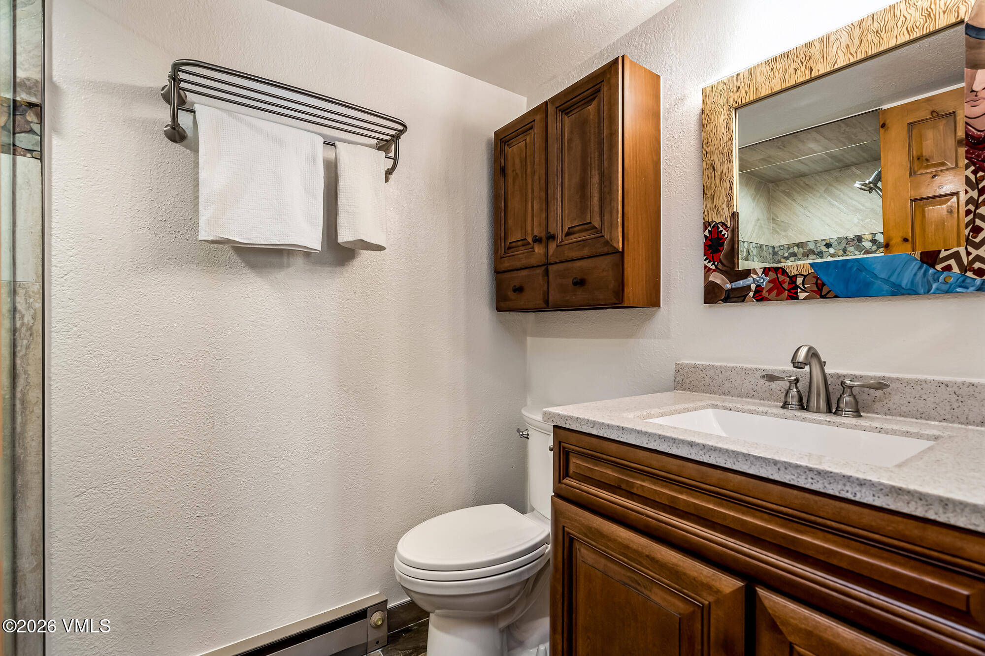 4470 Timber Falls Court, Unit 1405 Vail, CO 81657 - Photo 19 of 35 a bathroom with a granite countertop toilet sink and mirror