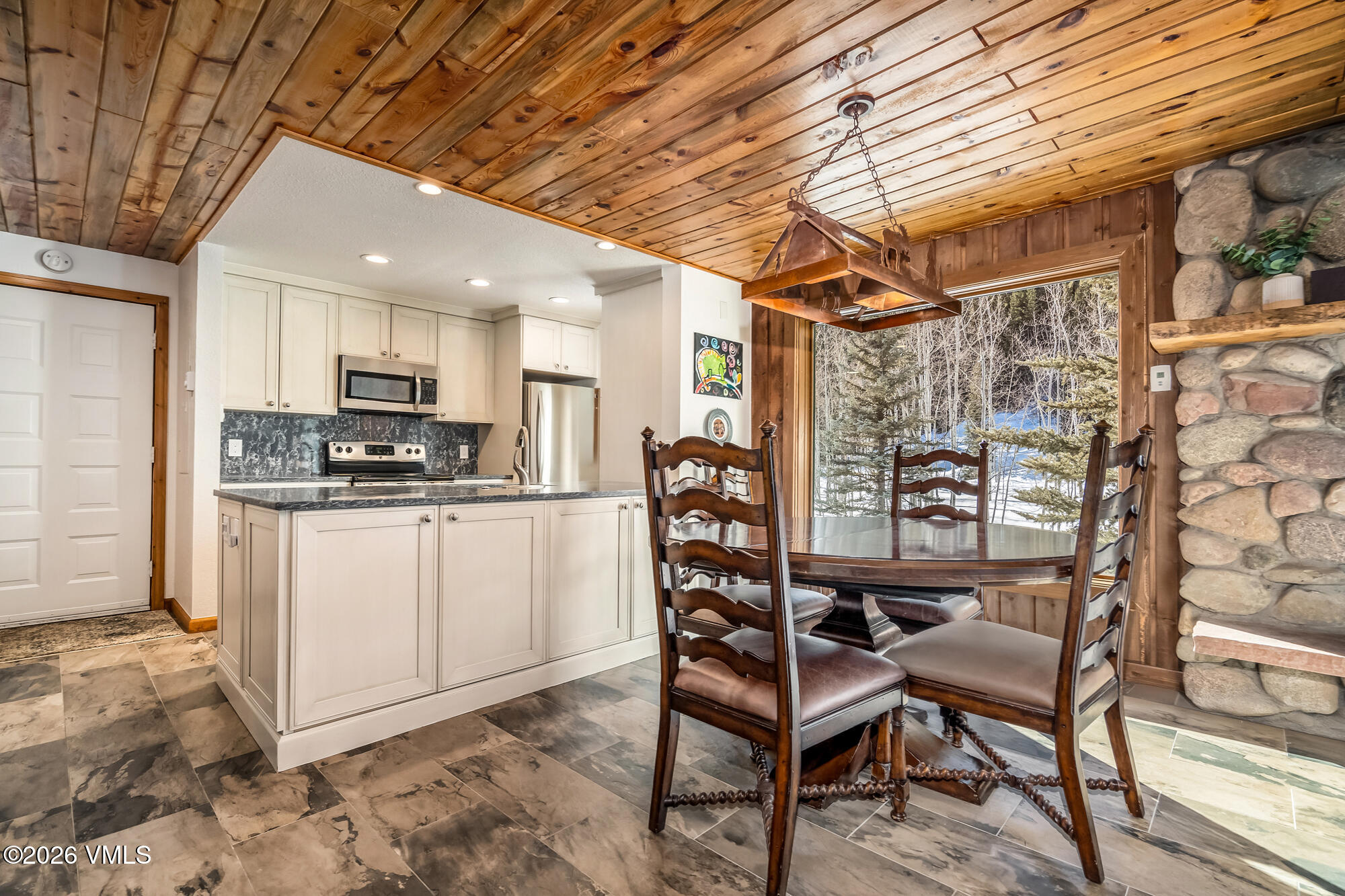 4470 Timber Falls Court, Unit 1405 Vail, CO 81657 - Photo 7 of 35 a kitchen with stainless steel appliances kitchen island granite countertop a refrigerator and microwave