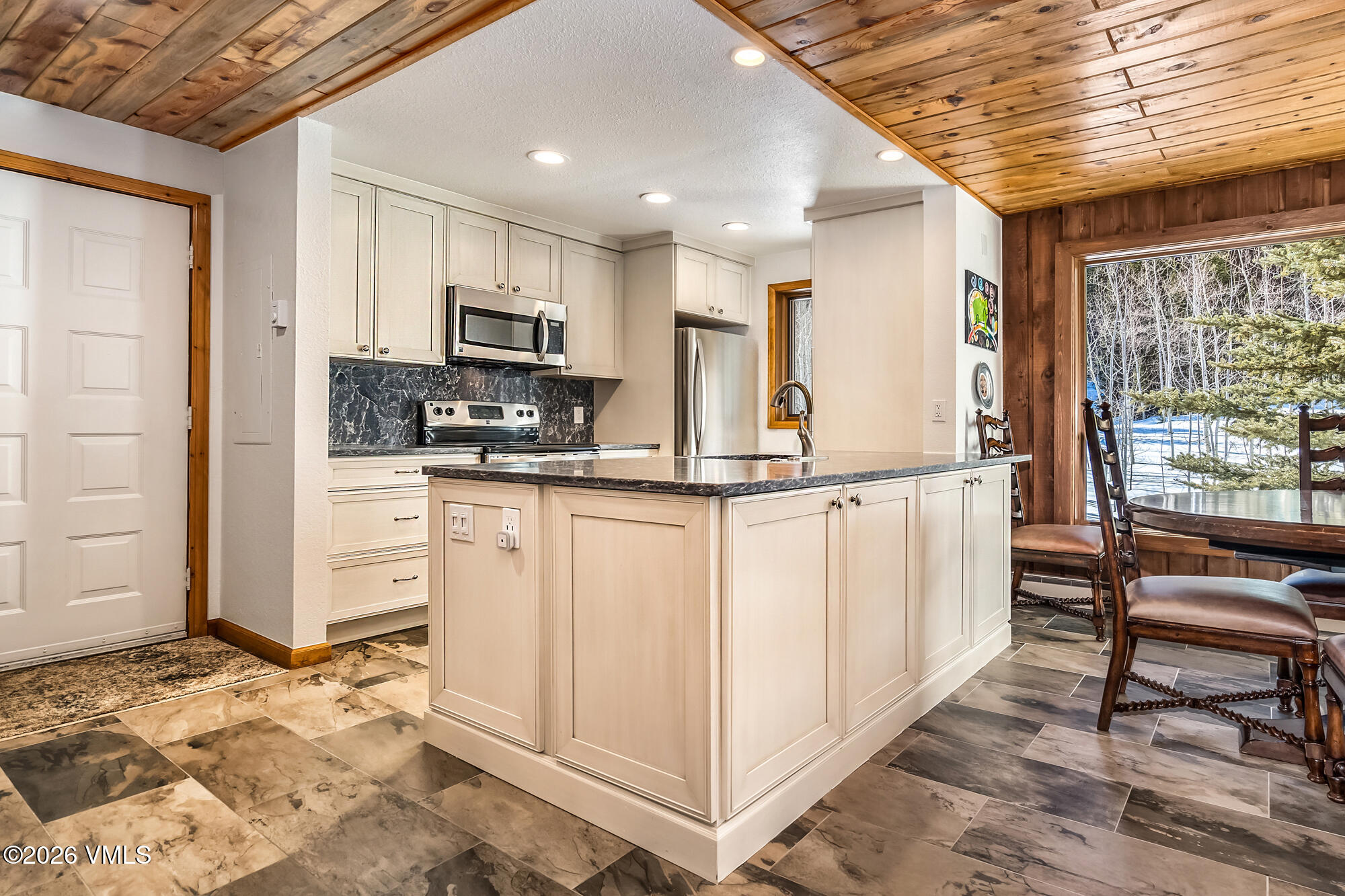 4470 Timber Falls Court, Unit 1405 Vail, CO 81657 - Photo 8 of 35 a kitchen with granite countertop cabinets and flat screen tv