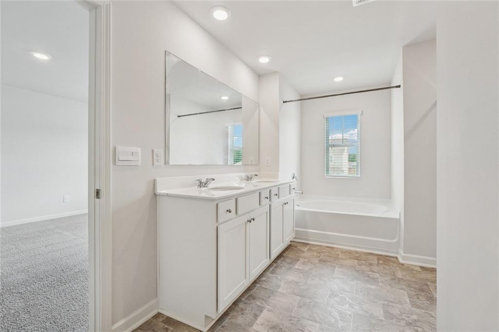 96 Quail Bend Way Dallas, GA 30157 - Photo 23 of 57 a bathroom with a sink a mirror and a bathtub
