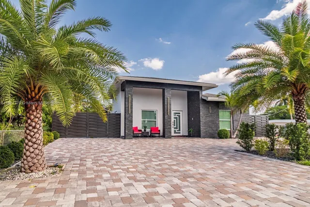 a front view of a house with a yard and potted plants