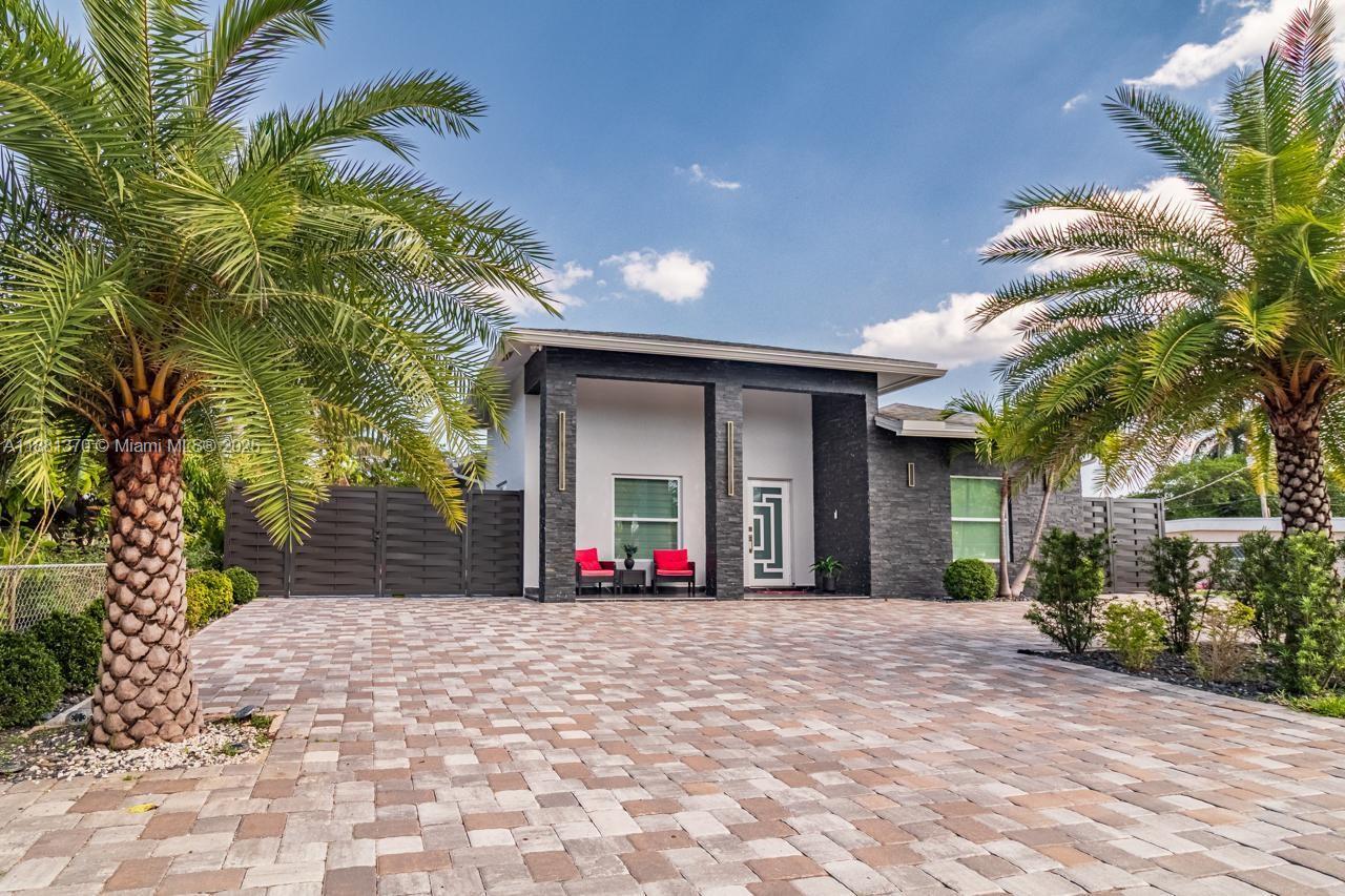 a front view of a house with a yard and potted plants