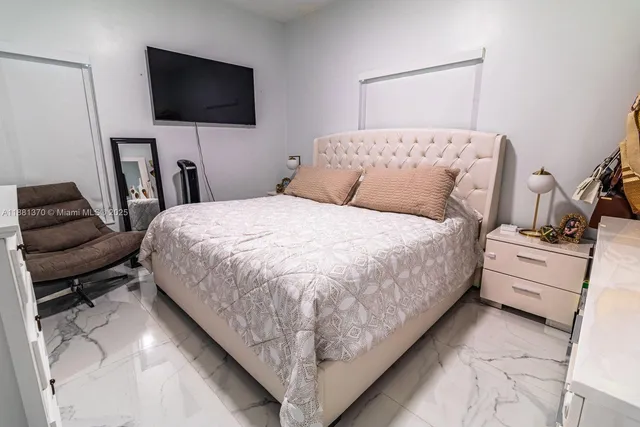 a bedroom with a bed and a flat screen tv