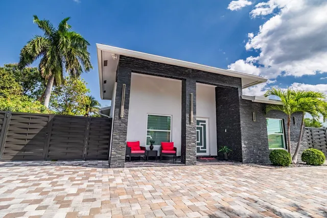 a view of a house with a small yard and potted plants