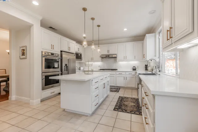 a kitchen with stainless steel appliances kitchen island granite countertop a sink and cabinets