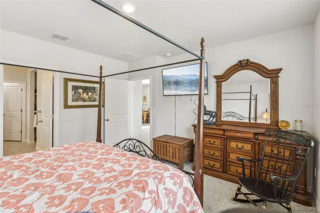 a bedroom with a bed a dresser and chair