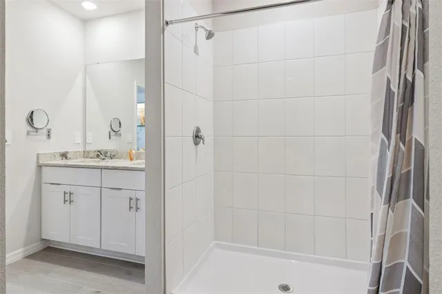 a bathroom with a shower and a sink a mirror