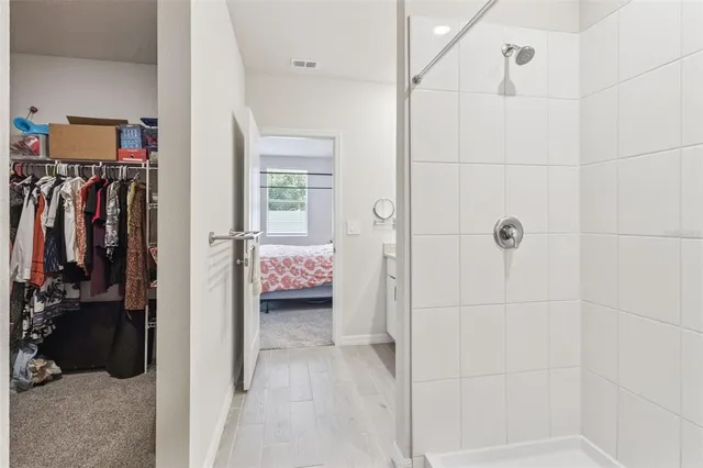 a view of walk in closet with clothes and shoes