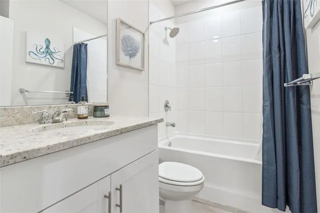 a bathroom with a granite countertop sink a toilet and bathtub