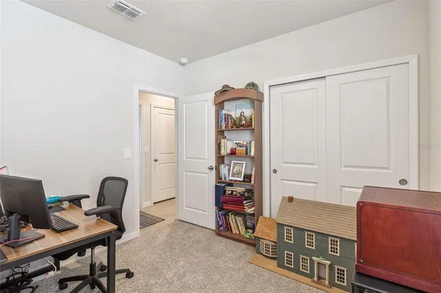 a view of a workspace with furniture and a window
