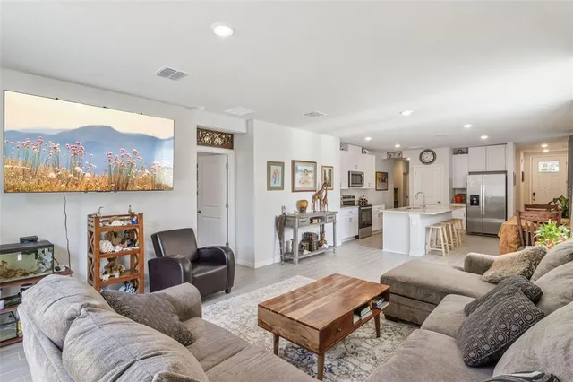 a living room with furniture and a view of kitchen