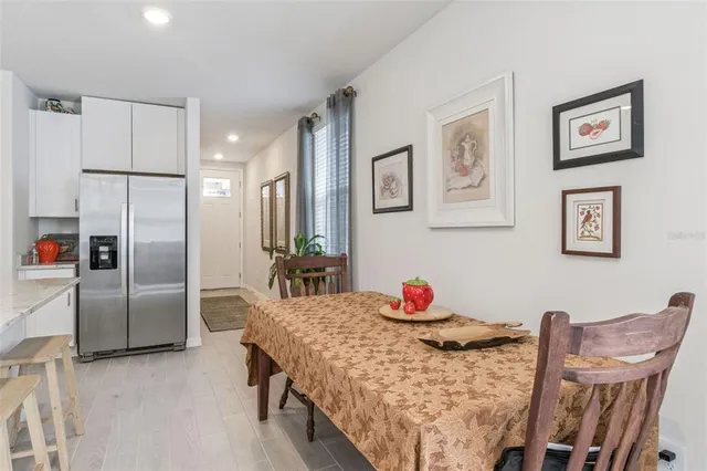 a bedroom with stainless steel appliances furniture a refrigerator and a dining table