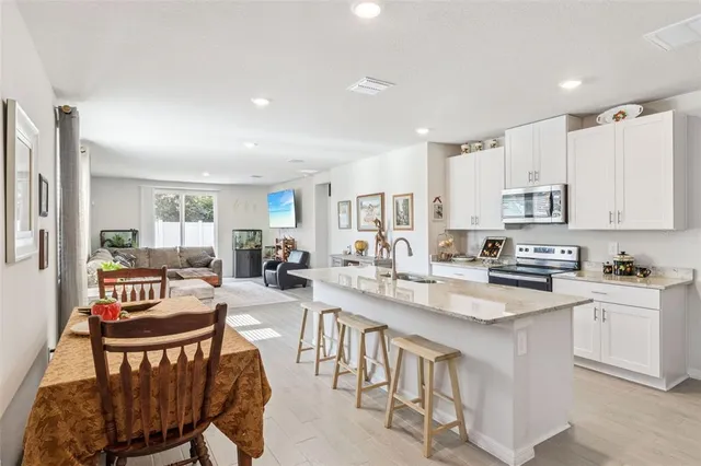 a large kitchen with a table and chairs