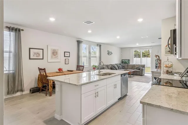 a large kitchen with kitchen island a sink stainless steel appliances and cabinets