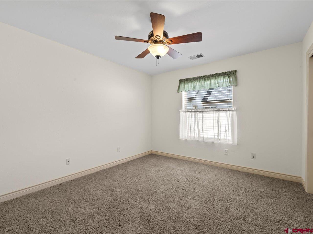 2001 Constitution Loop Montrose, CO 81401 - Photo 28 of 40 an empty room with ceiling fan and window