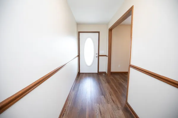 a kitchen with stainless steel appliances granite countertop wooden cabinets a refrigerator a sink a stove and a wooden floors