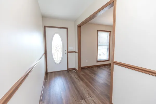 a kitchen with stainless steel appliances granite countertop a refrigerator a stove top oven a sink and dishwasher with wooden floor