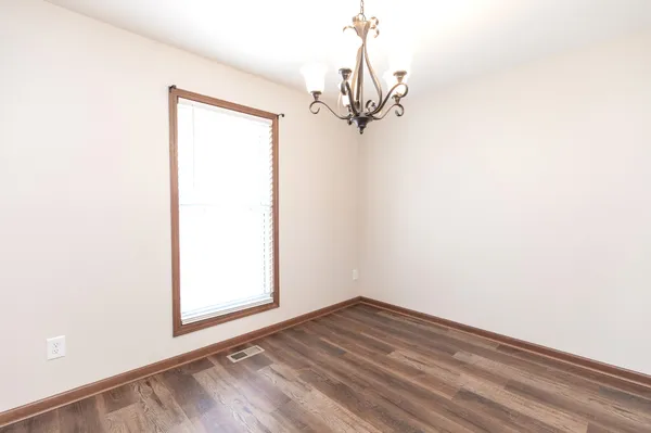 a kitchen with stainless steel appliances granite countertop a stove top oven a sink dishwasher and a refrigerator with wooden floor