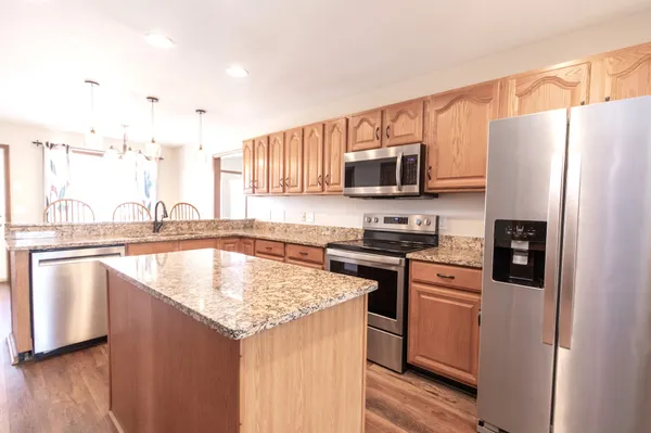a kitchen with granite countertop a sink and a refrigerator