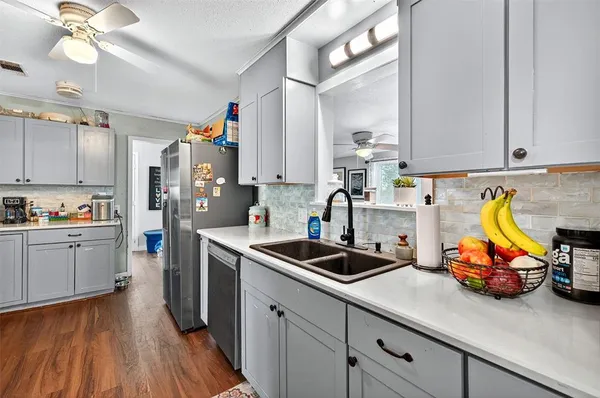 a kitchen that has a lot of cabinets a sink and appliances in it