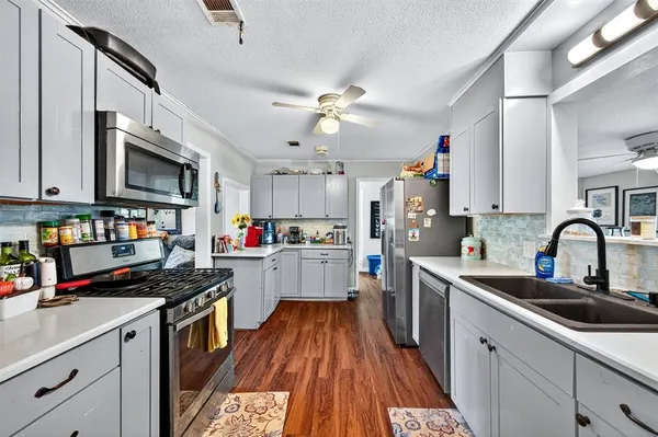 a kitchen with kitchen island granite countertop lots of counter top space and stainless steel appliances